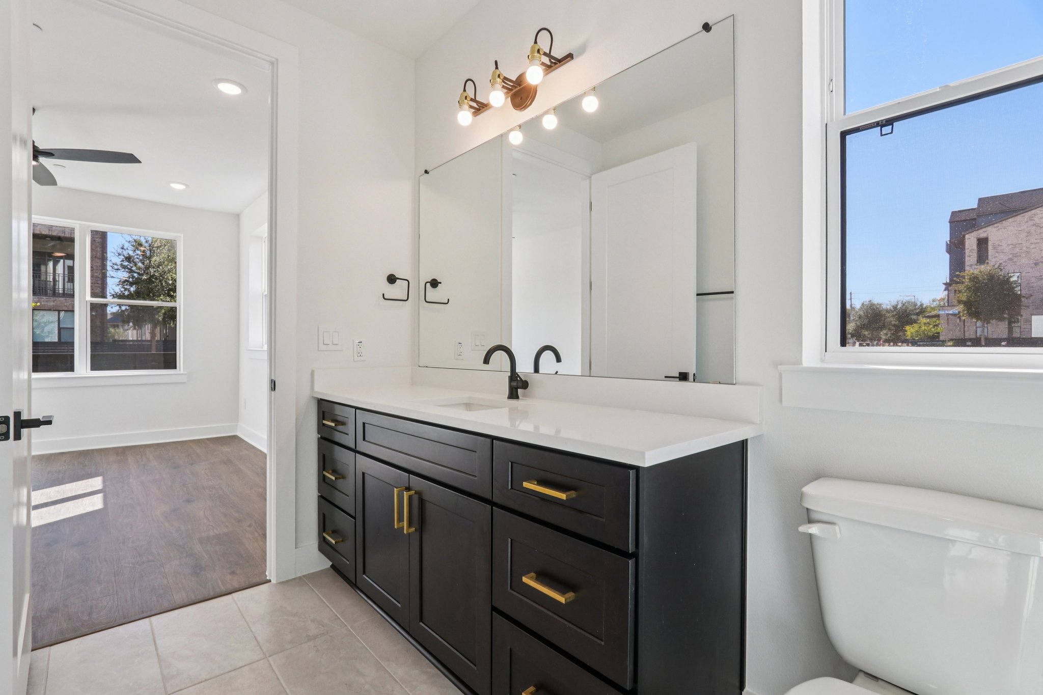 4311 Prevail Lane Austin, TX 78731 - Photo 21 of 40 a bathroom with a toilet a sink a mirror and a window