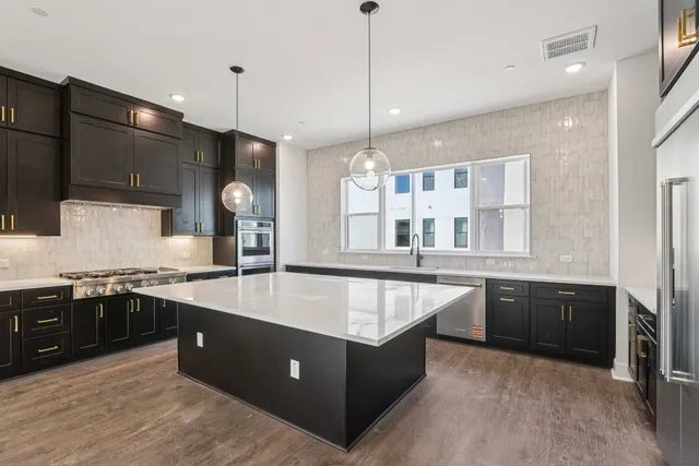a large kitchen with stainless steel appliances granite countertop a stove and a sink