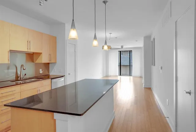 a kitchen with stainless steel appliances granite countertop a sink a stove and a wooden floors