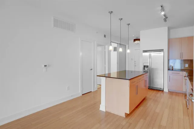 a kitchen with stainless steel appliances a refrigerator and wooden floor