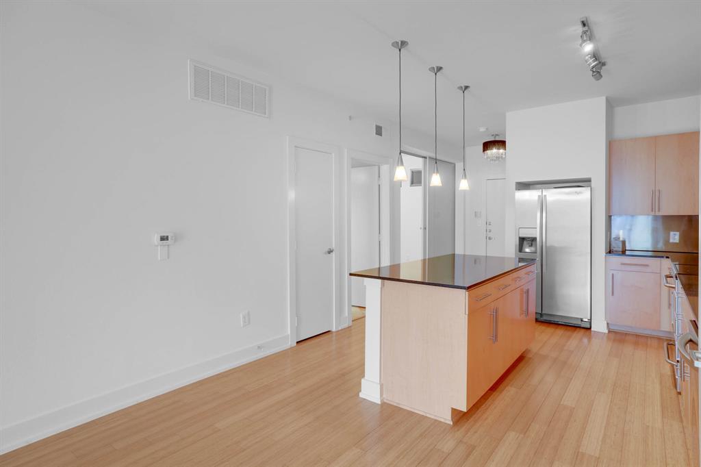 4333 Gilbert Avenue, Unit 215 Dallas, TX 75219 - Photo 5 of 19 a kitchen with stainless steel appliances a refrigerator and wooden floor
