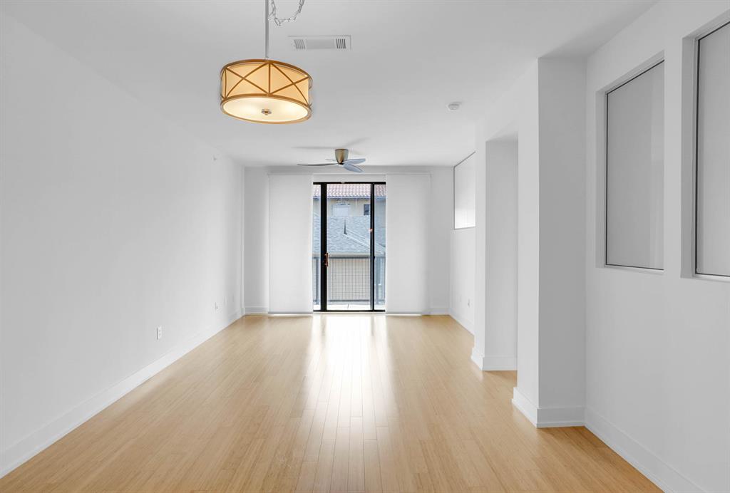 4333 Gilbert Avenue, Unit 215 Dallas, TX 75219 - Photo 7 of 19 an empty room with wooden floor and windows