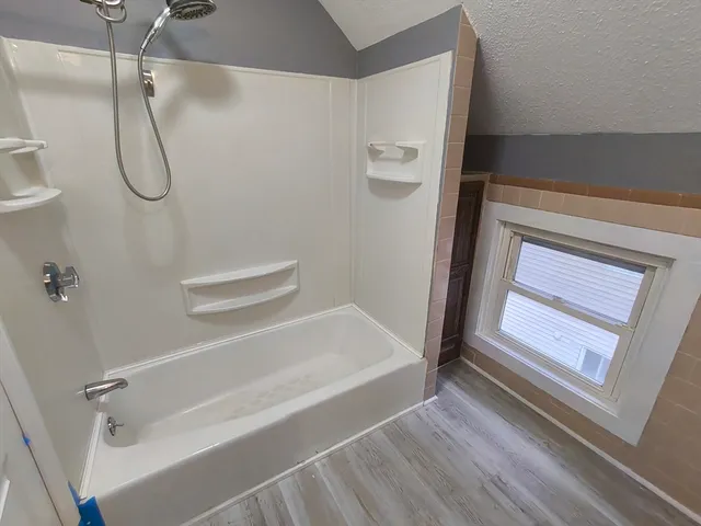 a bathroom with a bath tub with a shower