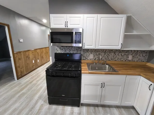 a kitchen with granite countertop a sink and a stove top oven
