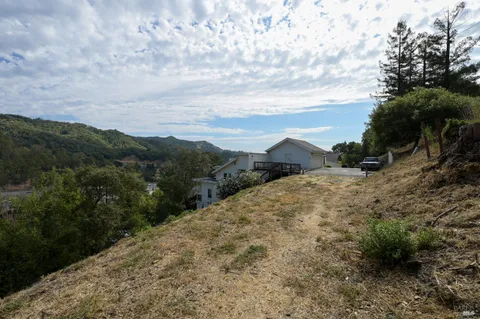 a view of a dry yard with mountains in the background