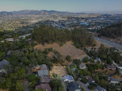 an aerial view of house with yard and mountain view in back