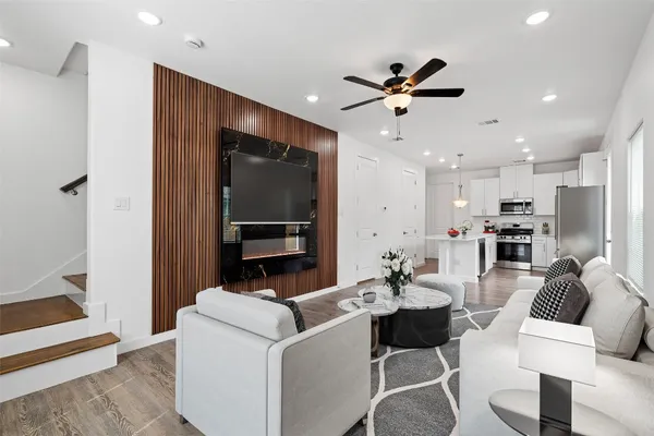 a living room with furniture and a view of kitchen
