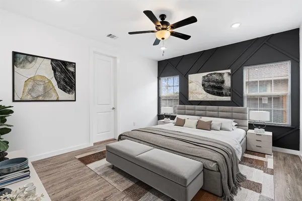 a bedroom with a large bed a flat screen tv and a painting on the wall