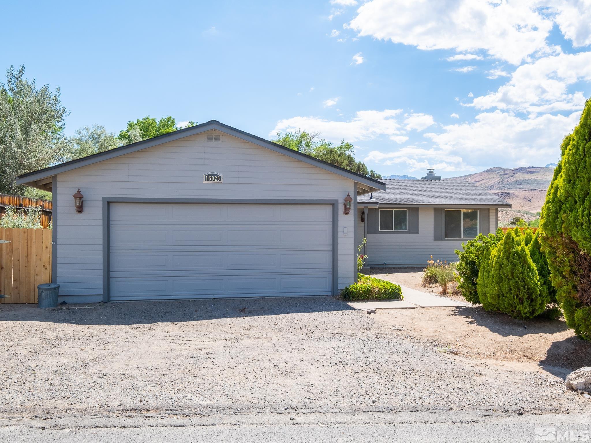 15025 Perlite Drive Reno, NV 89521 - Photo 1 of 24 a front view of house with yard and trees in the background