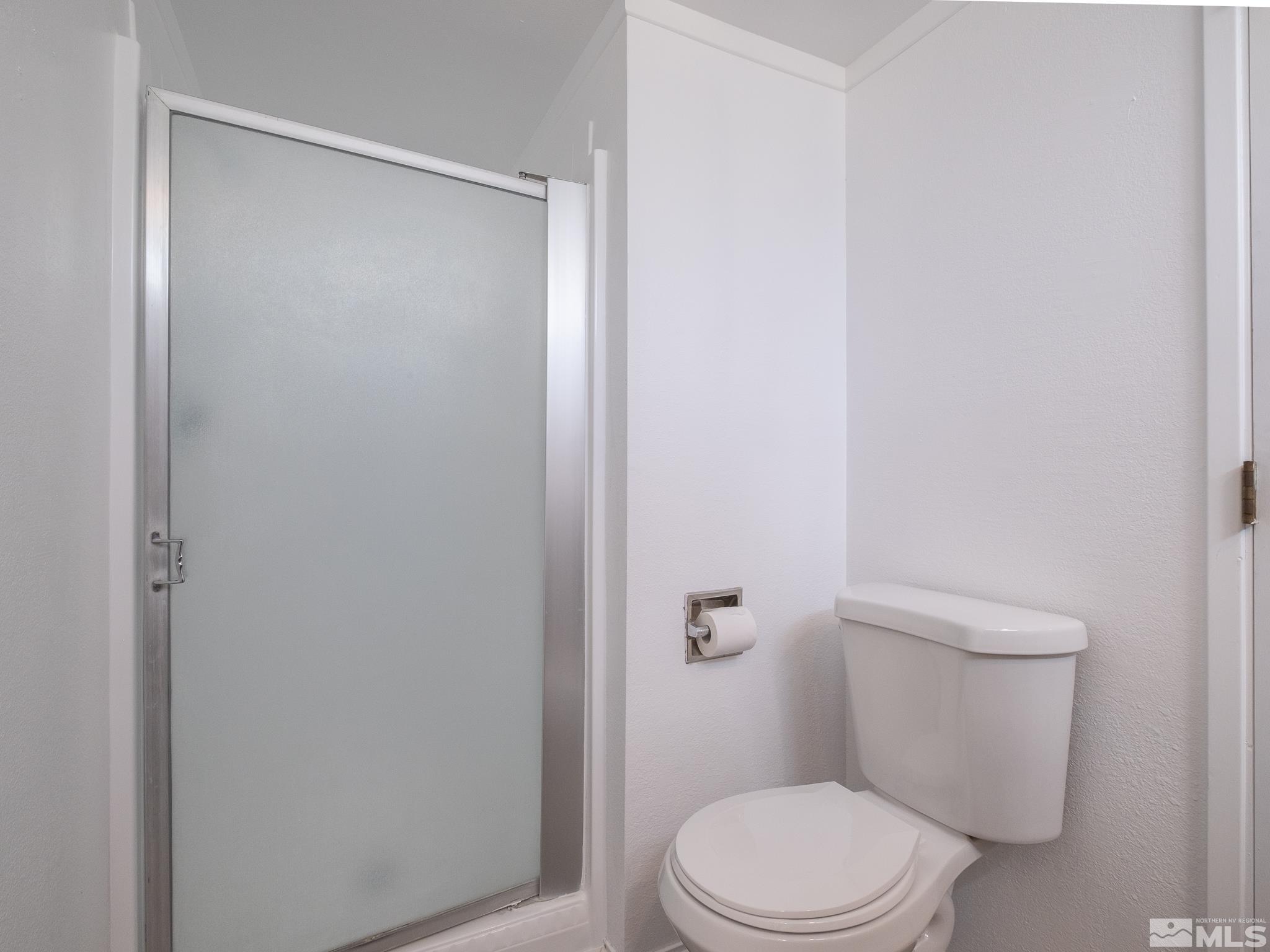 15025 Perlite Drive Reno, NV 89521 - Photo 18 of 24 a white toilet sitting next to a shower