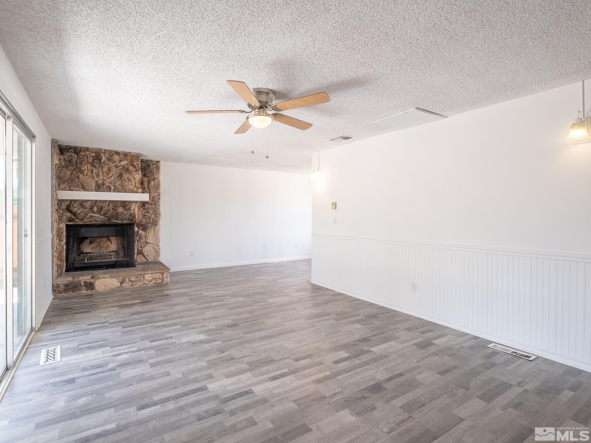 15025 Perlite Drive Reno, NV 89521 - Photo 3 of 24 a view of empty room with wooden floor and fireplace