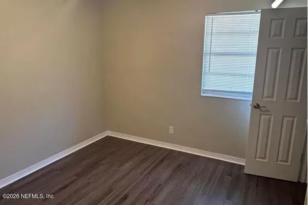 a view of a small space with wooden floor and a window