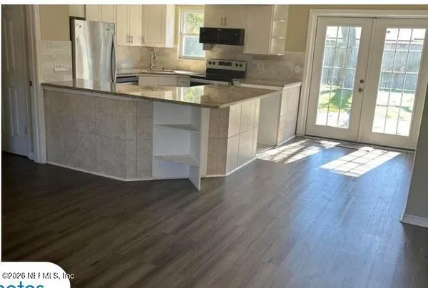 a kitchen with granite countertop a stove a sink and a granite counter top