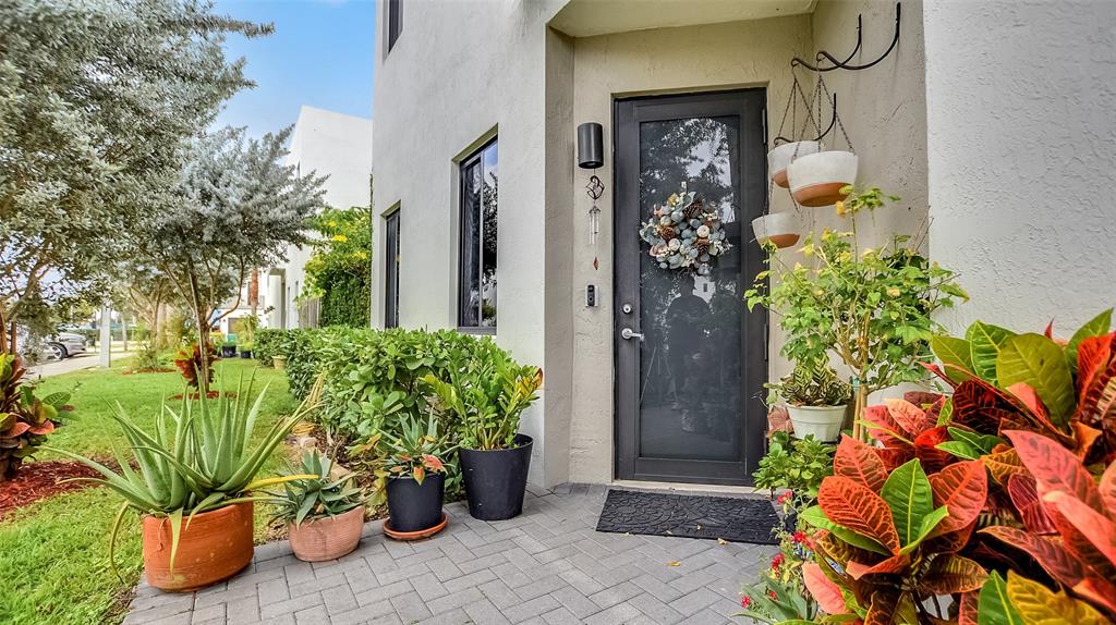 542 Southwest 91st Court, Unit 542 Miami, FL 33174 - Photo 2 of 33 a vase with flowers sitting on a floor in front of a door