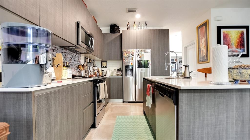 542 Southwest 91st Court, Unit 542 Miami, FL 33174 - Photo 5 of 33 a kitchen with stainless steel appliances granite countertop a sink and a refrigerator