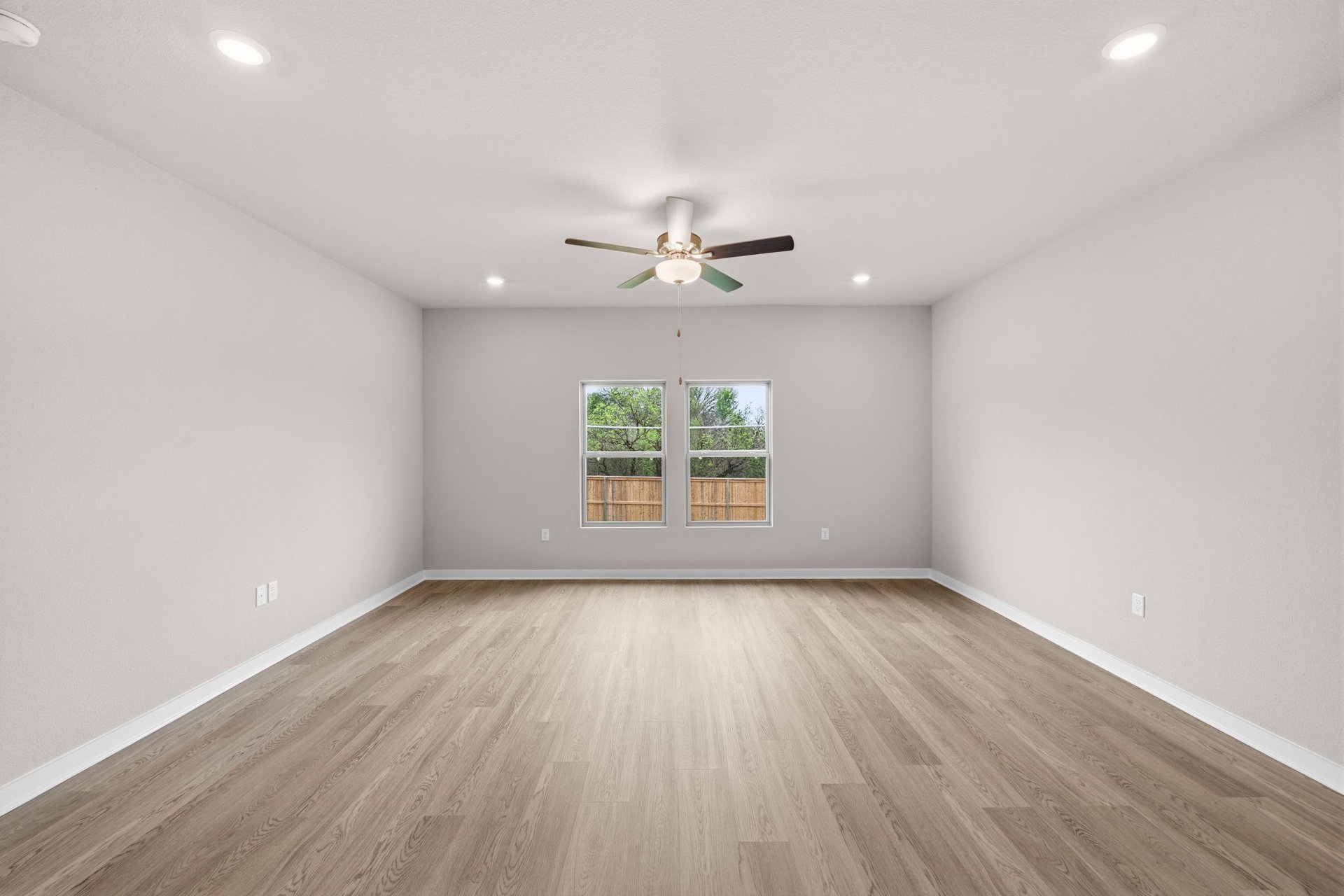 25517 Ashton Look Drive Elgin, TX 78621 - Photo 14 of 34 an empty room with wooden floor chandelier fan and windows