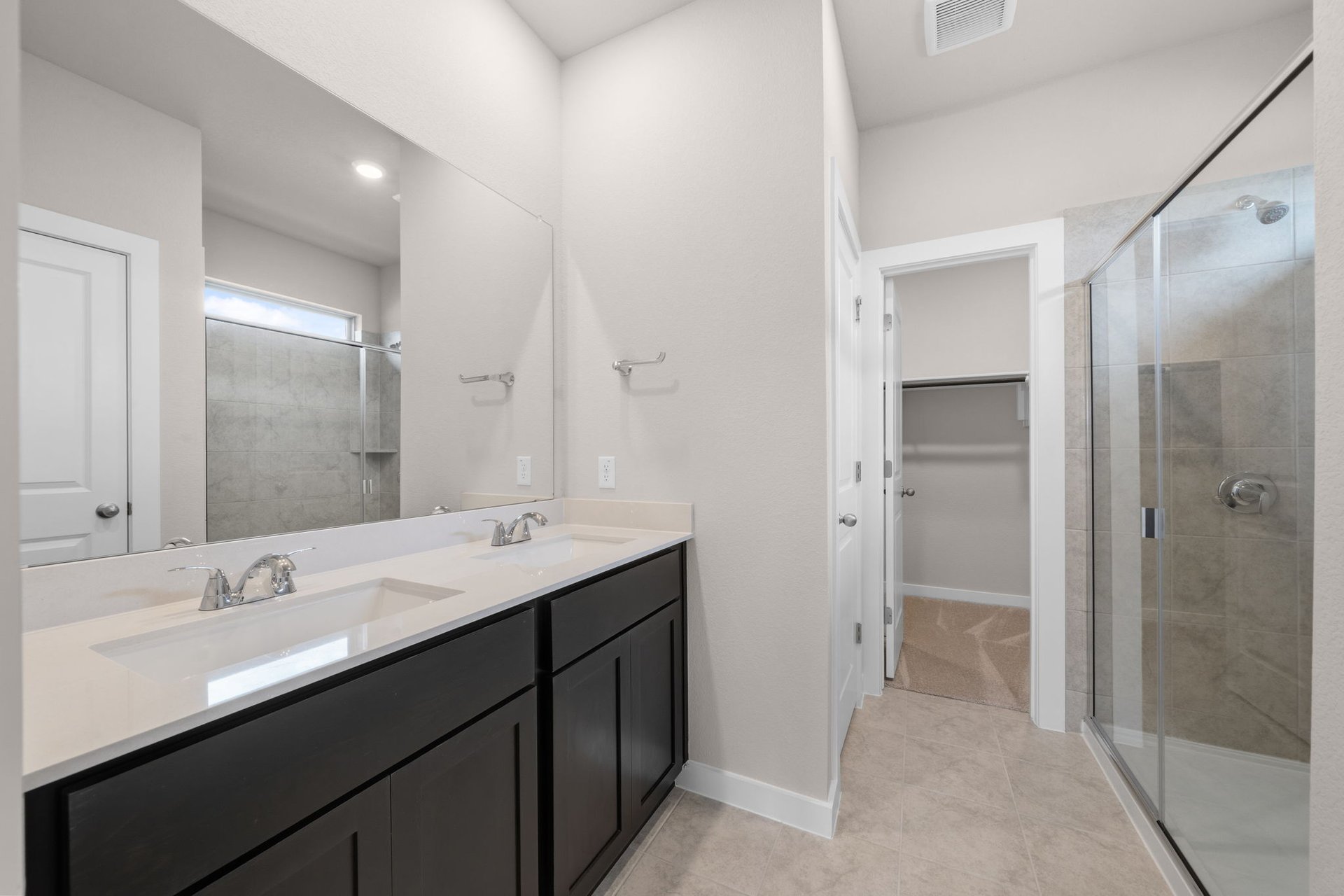 25517 Ashton Look Drive Elgin, TX 78621 - Photo 19 of 34 a bathroom with a double vanity sink mirror and shower