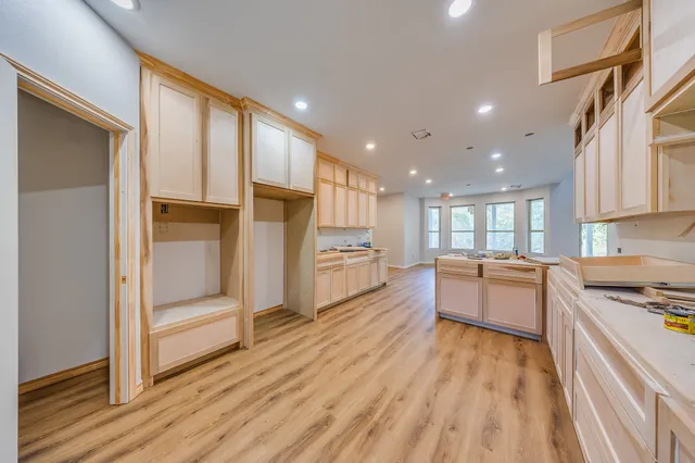 a kitchen with granite countertop a stove top oven and cabinets