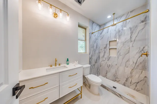 a bathroom with a sink a toilet and a shower