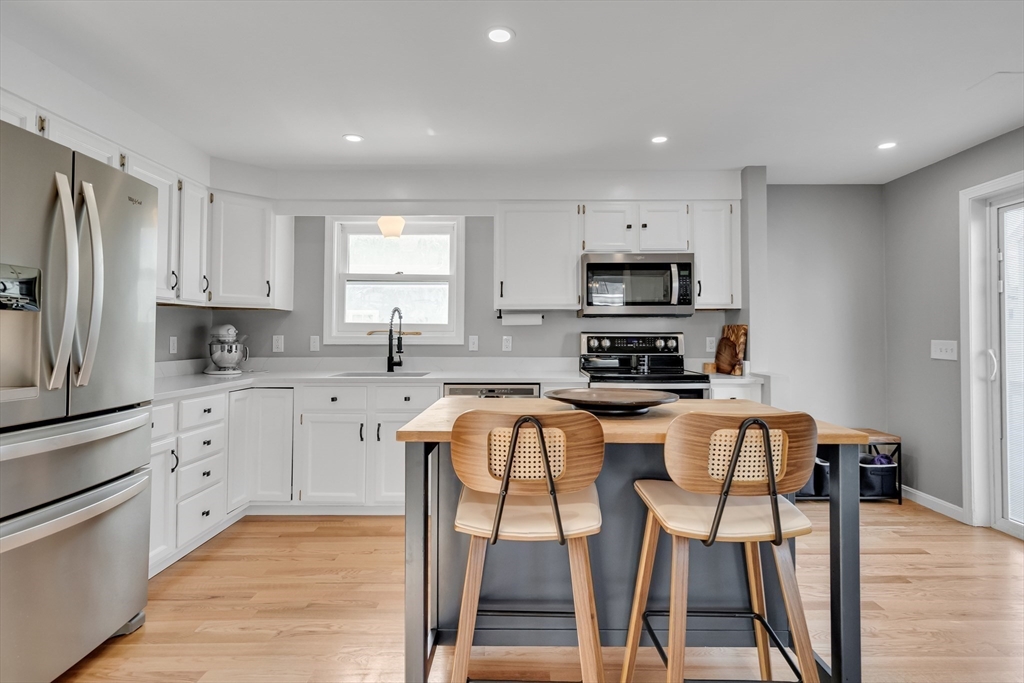 7 Long Terrace Boston, MA 02132 - Photo 12 of 42 a kitchen with stainless steel appliances granite countertop a stove a sink a microwave a refrigerator and white cabinets with wooden floor