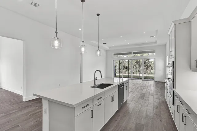 a kitchen with counter top space and wooden floor