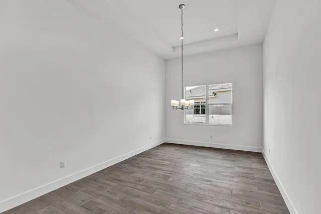an empty room with wooden floor and ceiling fan