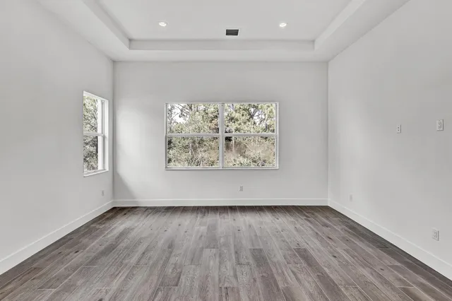 an empty room with wooden floor and window
