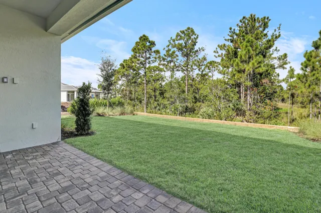 a front view of a house with a yard and palm trees