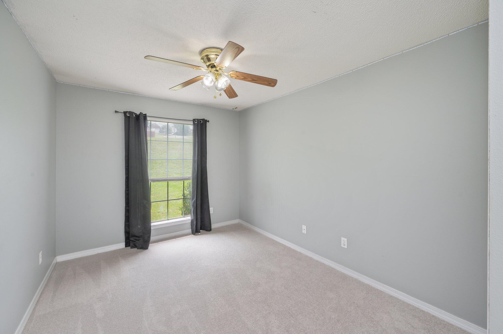 488 Jillian Drive Crestview, FL 32536 - Photo 19 of 29 an empty room with a chandelier fan and windows