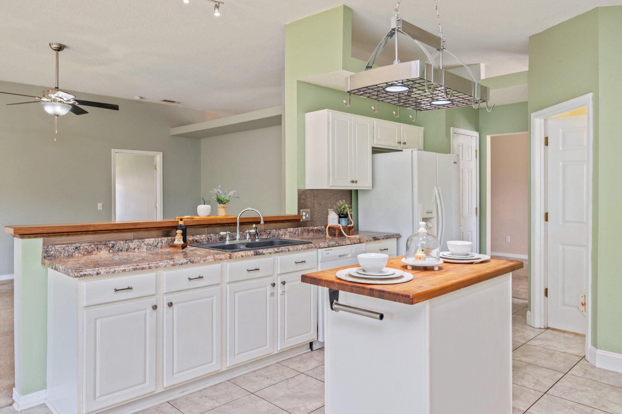 488 Jillian Drive Crestview, FL 32536 - Photo 5 of 29 a kitchen with a sink dishwasher and white cabinets with wooden floor