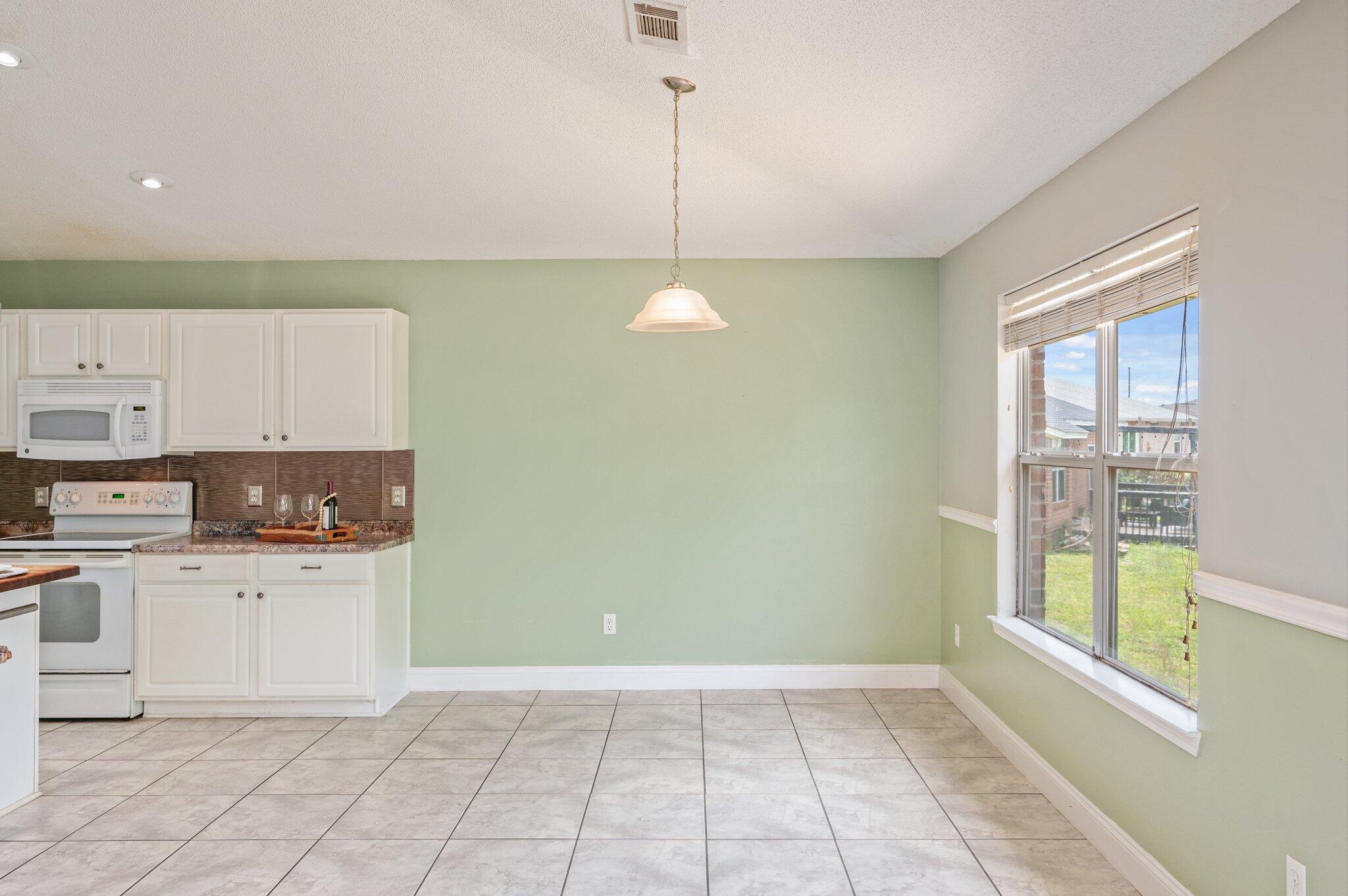 488 Jillian Drive Crestview, FL 32536 - Photo 9 of 29 a kitchen with white cabinets and window