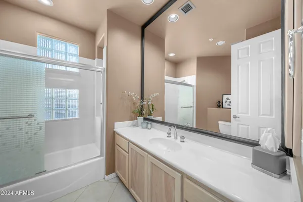 a bathroom with a tub sink and mirror