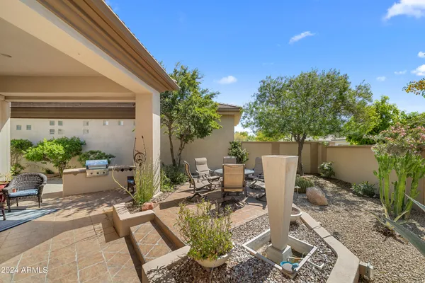 a view of a patio with table and chairs potted plants and floor to ceiling window