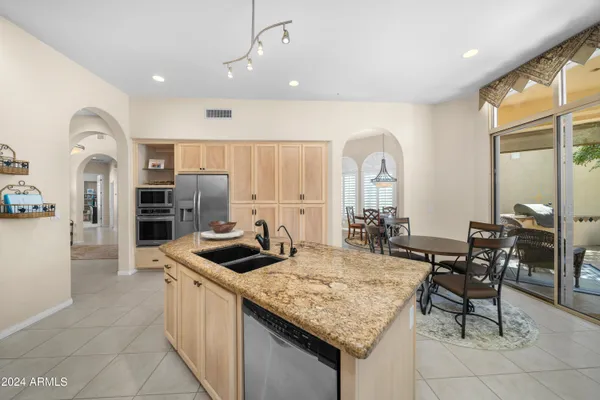 a kitchen with granite countertop a sink and a refrigerator