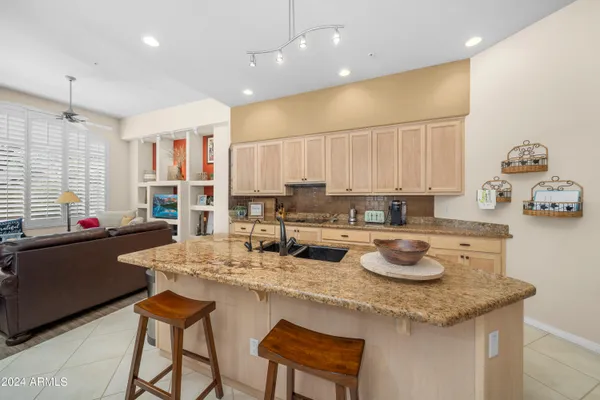 a kitchen with a sink a stove and chairs