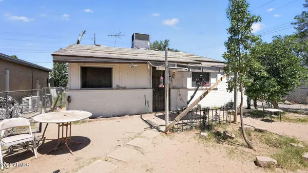a view of a patio with a table and chairs under an umbrella with wooden fence
