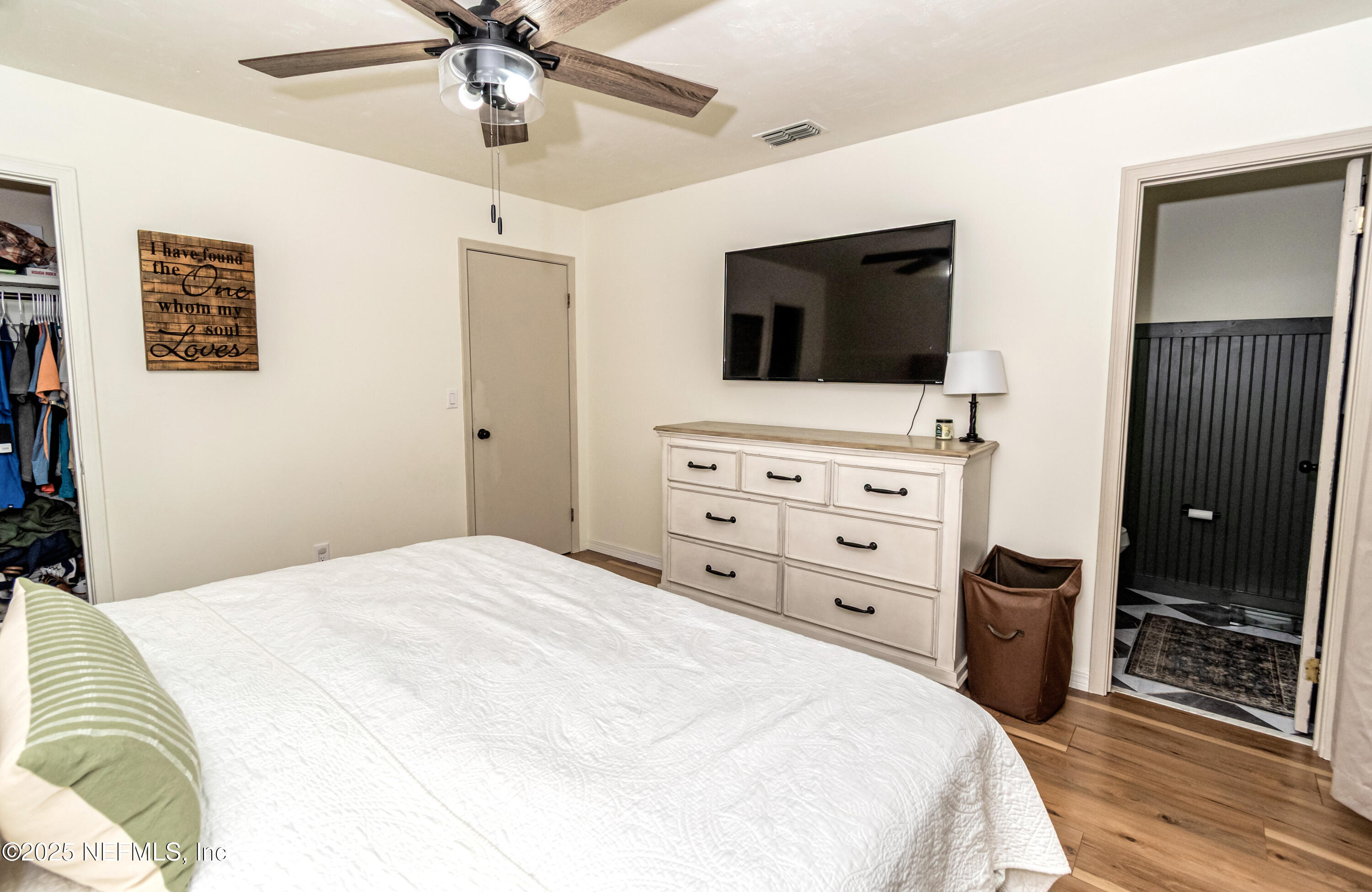 311 North 4th Street Macclenny, FL 32063 - Photo 12 of 35 a bedroom with a bed a chandelier and a flat screen tv