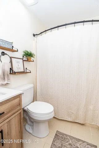 a white toilet sitting next to a shower curtain