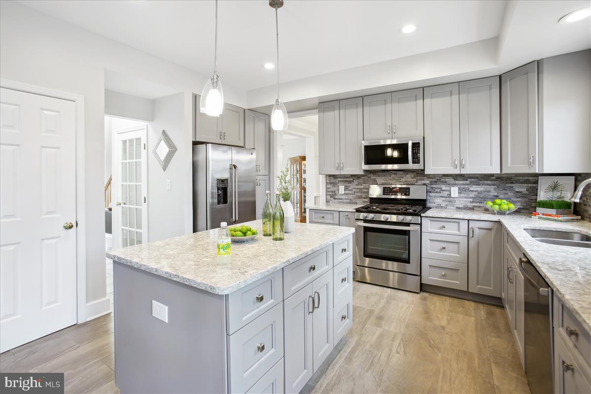 20702 Pomeroy Court Ashburn, VA 20147 - Photo 17 of 60 a kitchen with white cabinets and stainless steel appliances