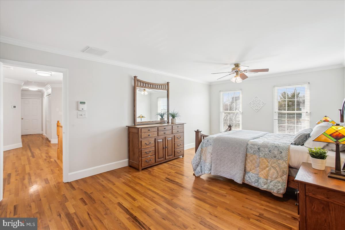 20702 Pomeroy Court Ashburn, VA 20147 - Photo 28 of 60 a bedroom with a bed and wooden floor