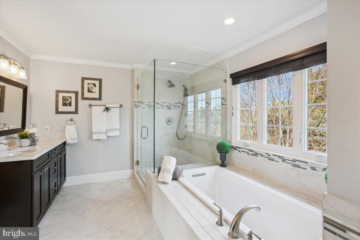 20702 Pomeroy Court Ashburn, VA 20147 - Photo 31 of 60 a spacious bathroom with a granite countertop tub shower and sink