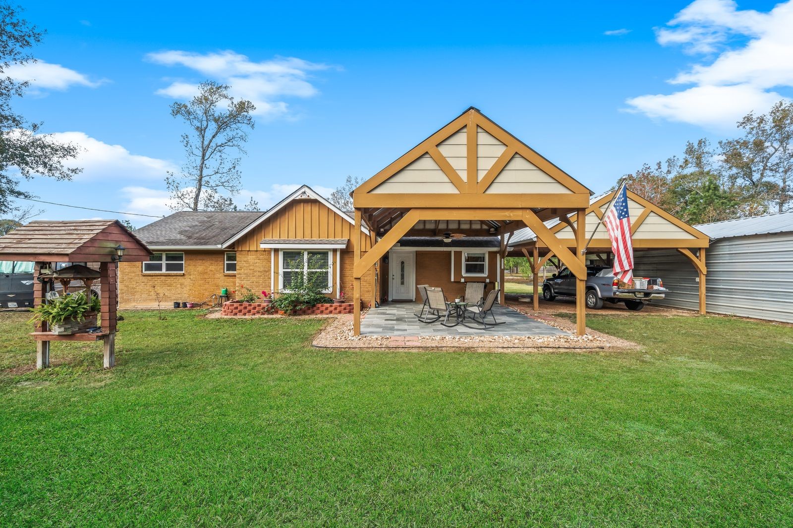 6742 Dusty Lane Conroe, TX 77306 - Photo 3 of 33 Charming single-story home with a welcoming front patio and wooden pergola. It features a spacious lawn, covered seating area, and attached carport. Perfect for outdoor relaxation and gatherings.