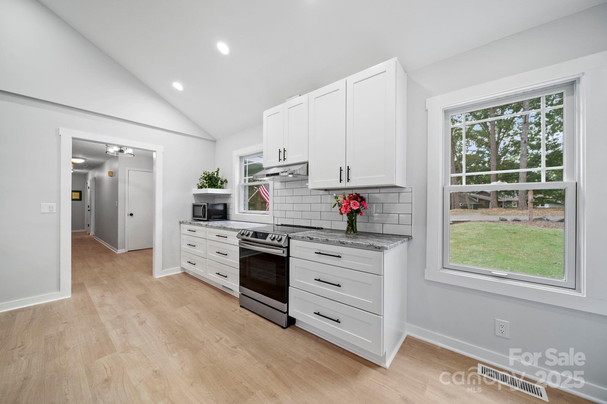 1215 Molokai Drive Fort Mill, SC 29708 - Photo 8 of 25 a kitchen with granite countertop white cabinets and stainless steel appliances