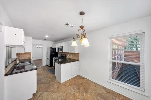 a view of a kitchen with kitchen island wooden floor and windows