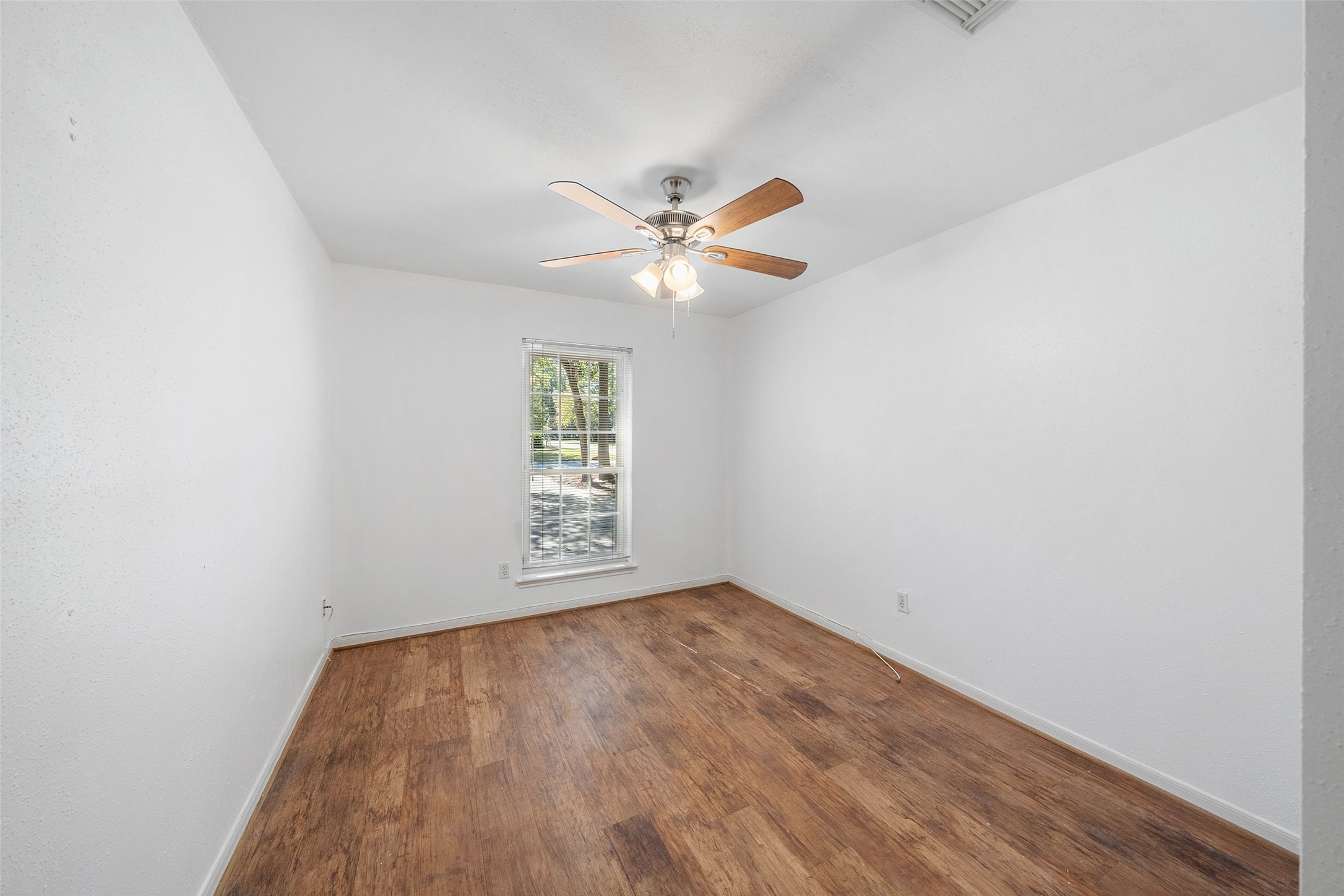 107 Sandpebble Drive The Woodlands, TX 77381 - Photo 15 of 30 an empty room with a window and a fan
