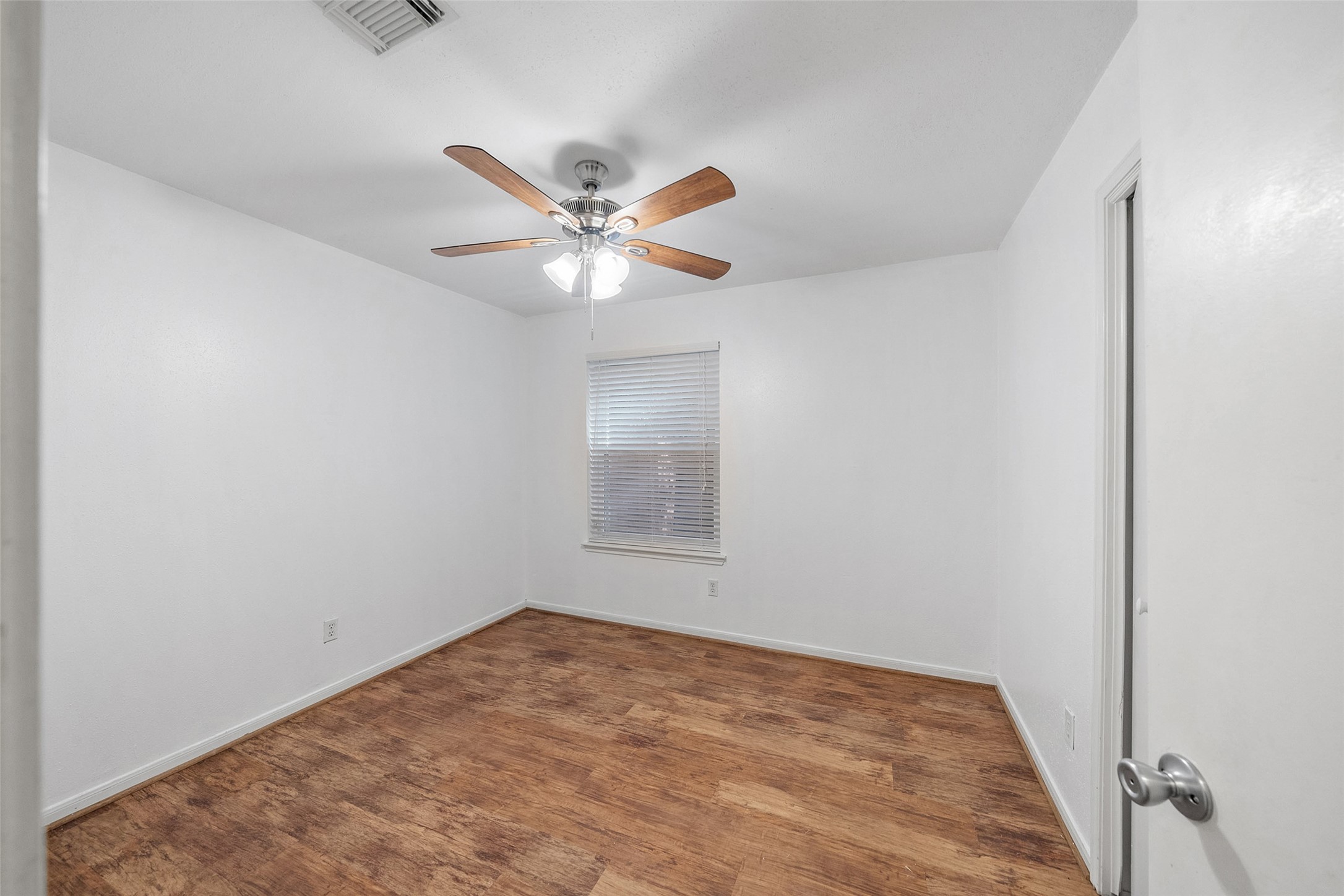 107 Sandpebble Drive The Woodlands, TX 77381 - Photo 20 of 30 an empty room with a chandelier fan and a window