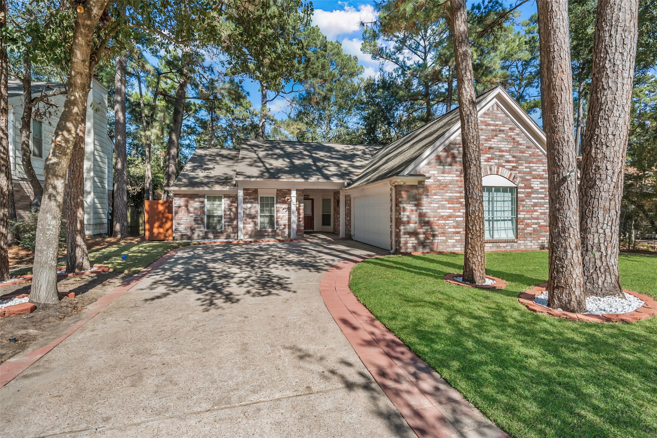 107 Sandpebble Drive The Woodlands, TX 77381 - Photo 2 of 30 a view of a house with a yard