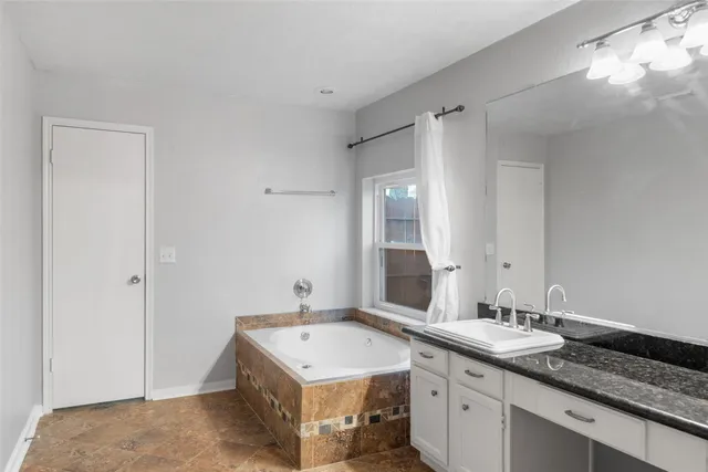 a spacious bathroom with a double vanity sink and a mirror