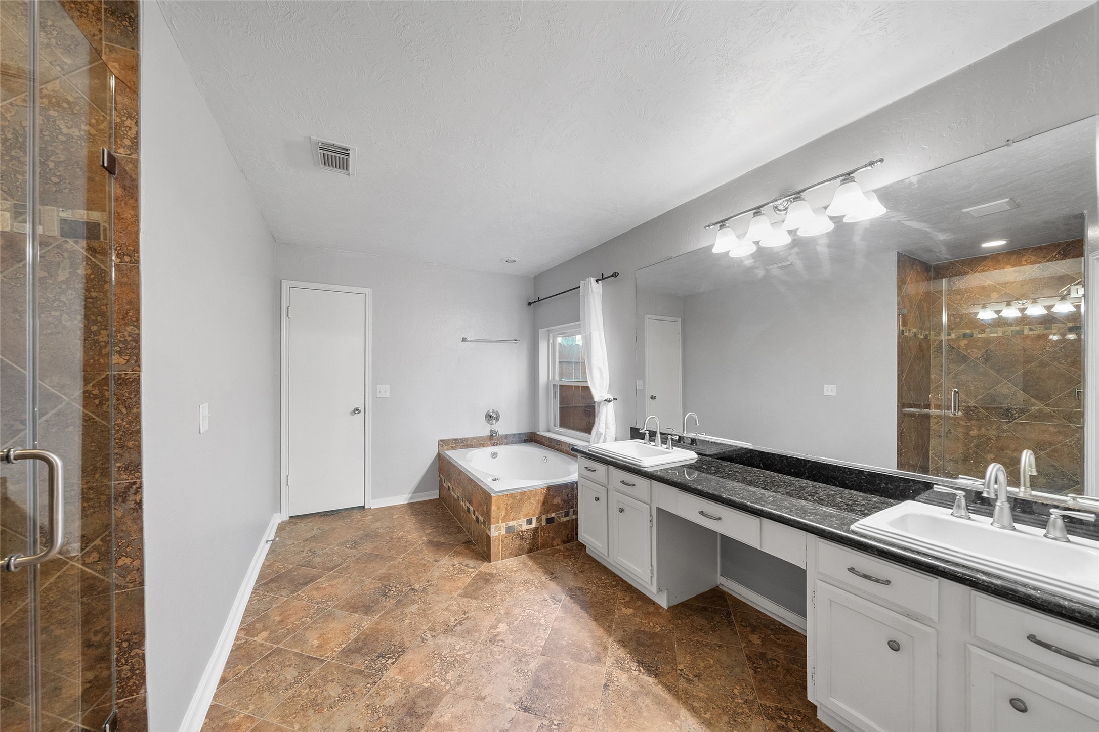 107 Sandpebble Drive The Woodlands, TX 77381 - Photo 23 of 30 a spacious bathroom with a double vanity sink and a mirror