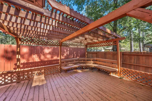 a view of a house with backyard wooden fence and a large tree